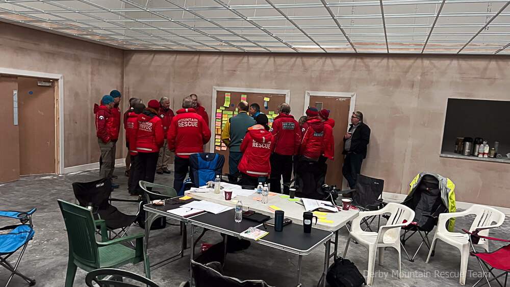 Team members and peer reviewers gathered around a board of sticky notes during Saturday's review session