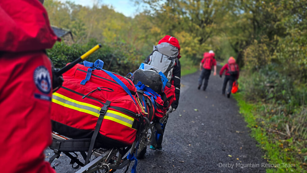 A loaded stretcher and kit being wheeled along a woodland track as team members head out on Sunday's exercise